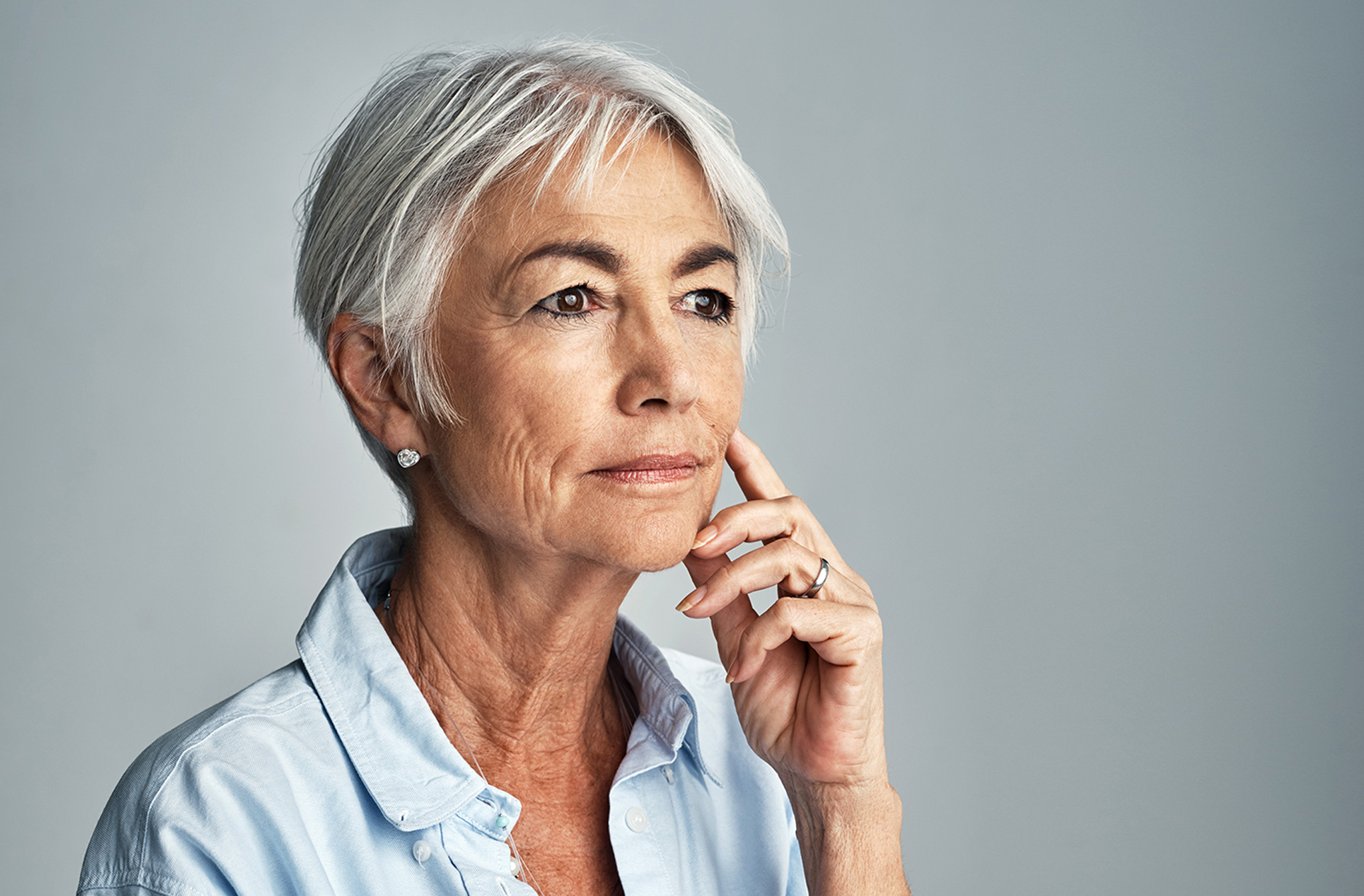 A woman touches her chin and cheek, looking toward the distance in contemplation. The disability lawyers at The Clarkson Firm provides answers to frequently asked questions about disability benefits.