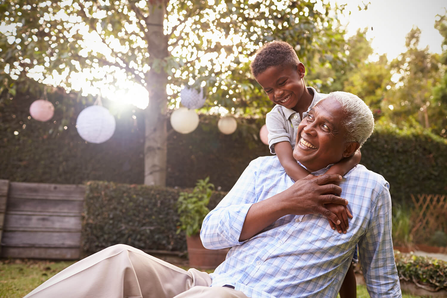 Out in a yard, a man with gray hair gets a hug from a young boy. In certain circumstances, it's possible to get disability benefits for dependents and spouses.