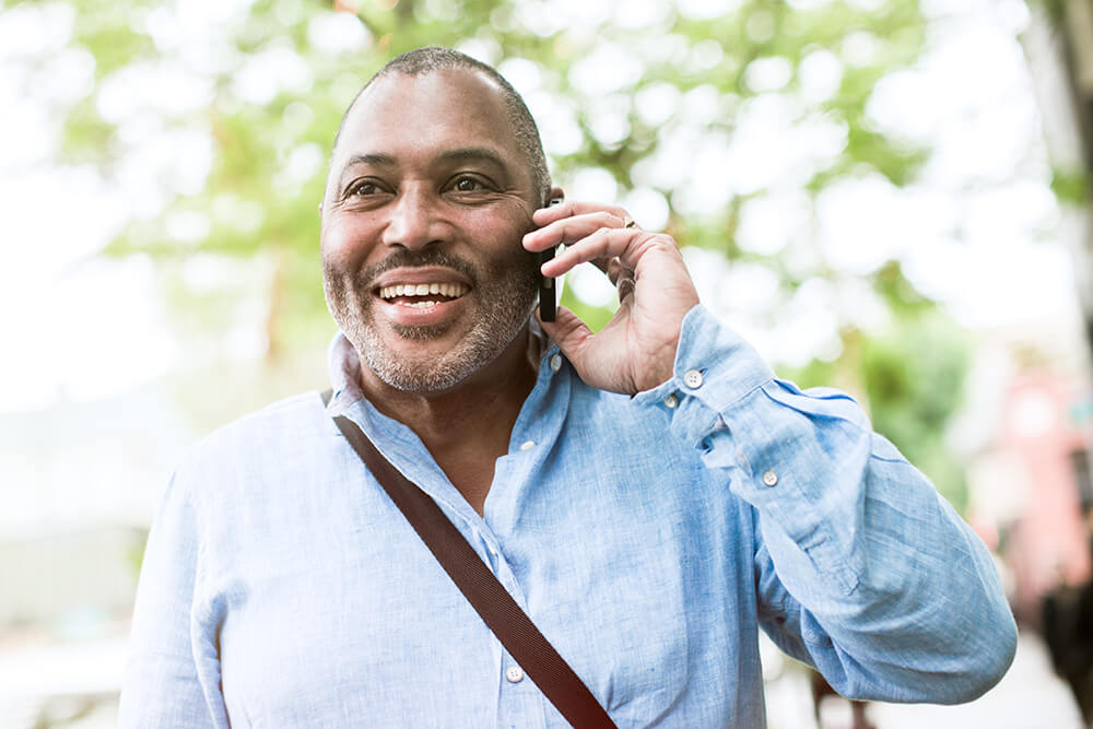 A man in a park, talking on his mobile phone. The Clarkson Firm disability attorneys can answer questions about getting Social Security Disability benefits.